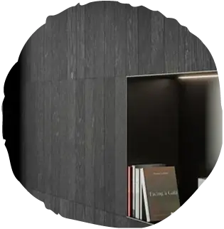 Detail vestavěné niky v tmavém dřevěném obkladu Oakcent Ink, kde rafinovaný povrch s přiznanou kresbou dubu vytváří silnou atmosféru a elegantní pozadí pro knihy a doplňky.