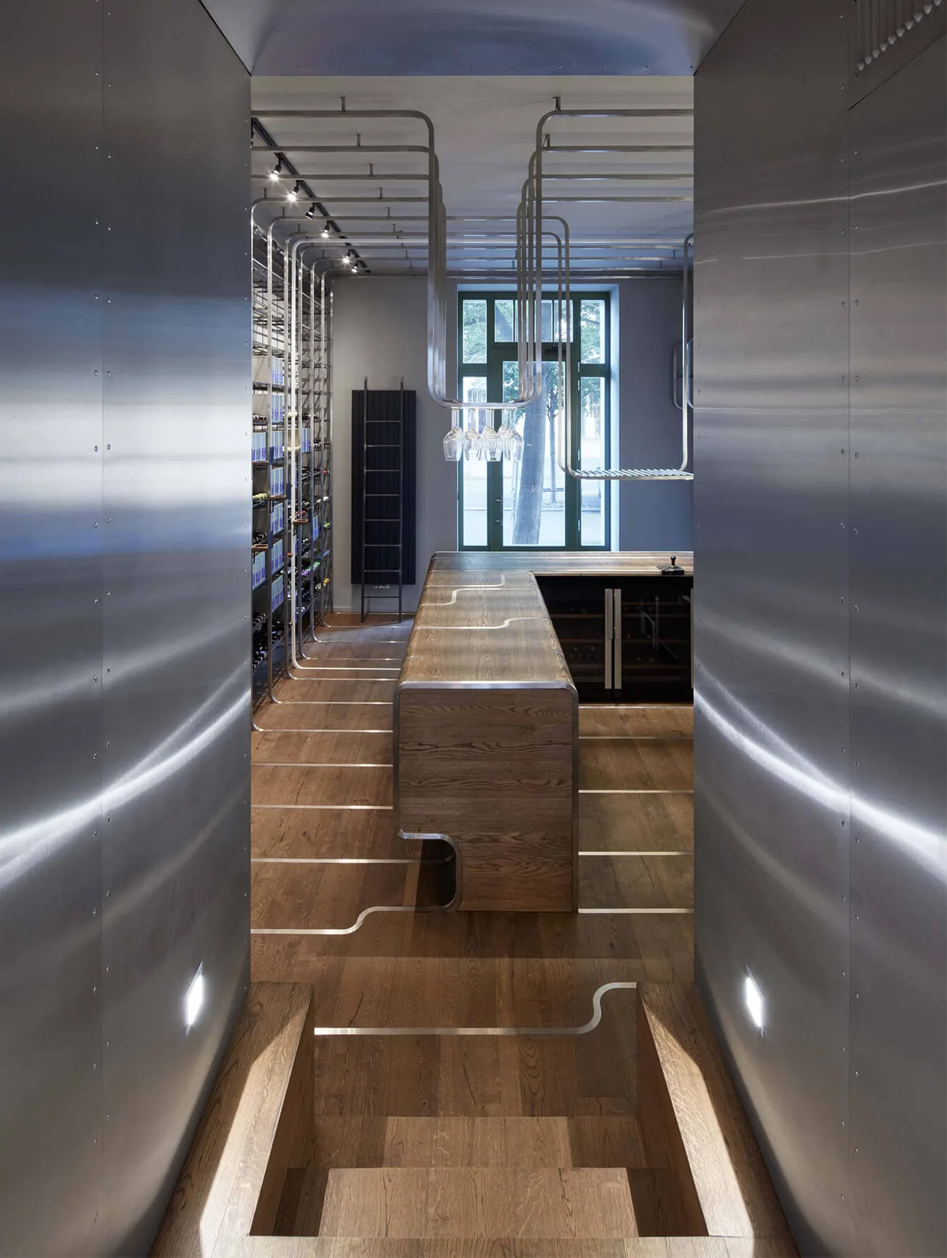 Moderní industriální interiér vinotéky nebo baru s tmavou dřevěnou podlahou Hazel, do které jsou zapuštěny dekorativní kovové linie plynule přecházející z podlahy na stěny a nábytek.